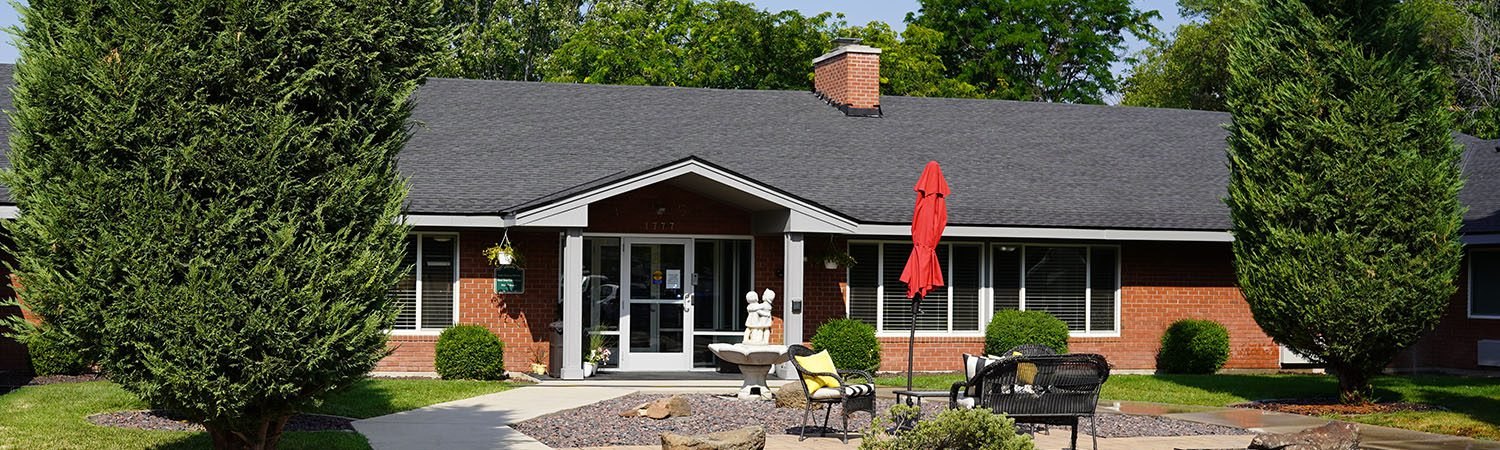 The Boise Rescue Mission's Next Step building on Curtis Road — a low brick building with a garden and seating out front